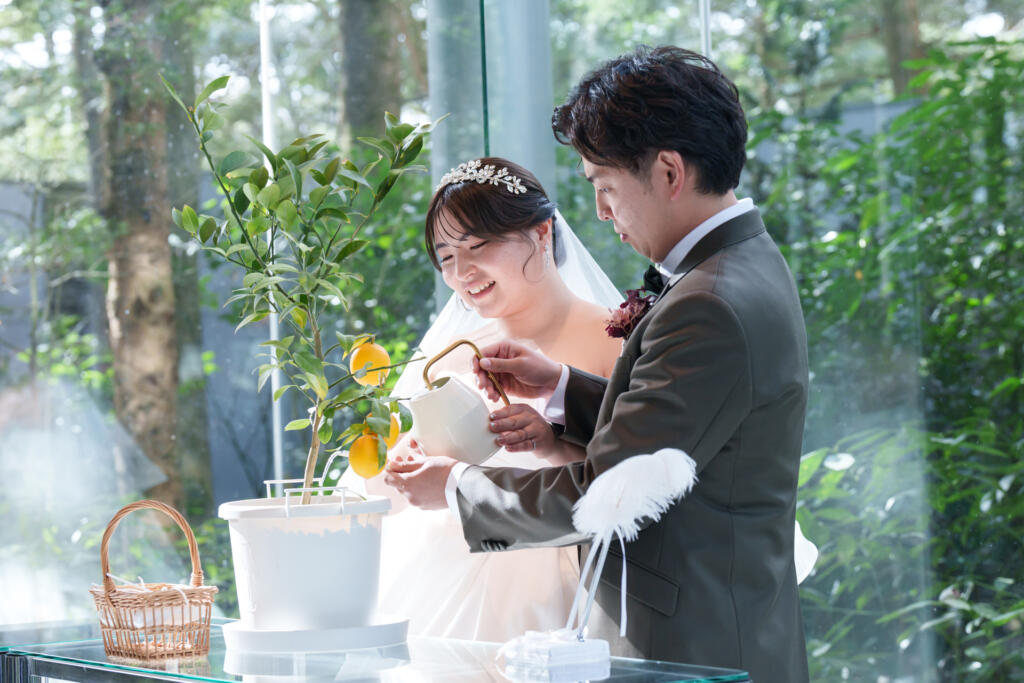 「植樹の儀」。ゲストの愛が詰まった土に、二人で水を注ぎ結婚証明書が完成!全面ガラス張りチャペルで叶える特別な絆。
