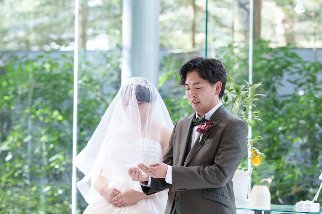 軽井沢の全面ガラス張りチャペルで、愛の誓いの言葉を。森の緑と光に見守られ、二人で未来を創る感動の瞬間。
