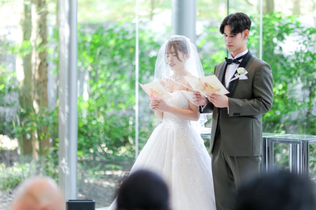 軽井沢の全面ガラス張りチャペルで誓う、感動的な結婚式。自然光と森の緑がウェディングドレスを美しく際立たせます。ゲストに見守られ、愛を誓う特別な瞬間に。