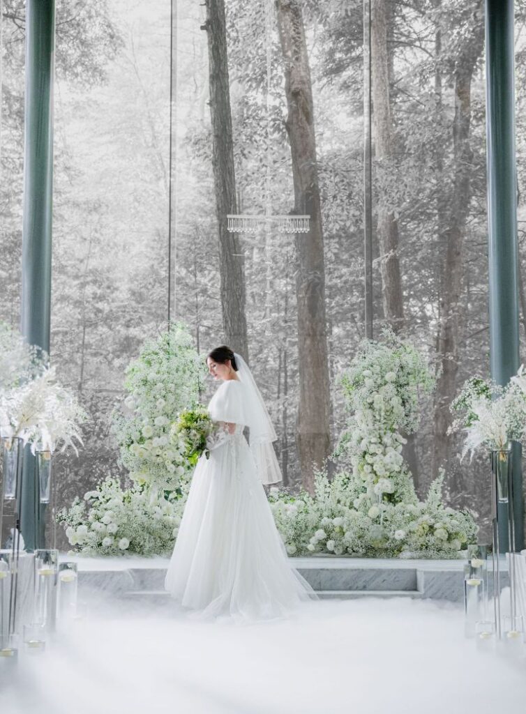 アネーリ軽井沢の冬のウェディング。雪景色が背景のガラスのチャペルで、白い装花と霧に包まれた花嫁。軽井沢リゾート婚の美しいチャペル挙式の様子。
