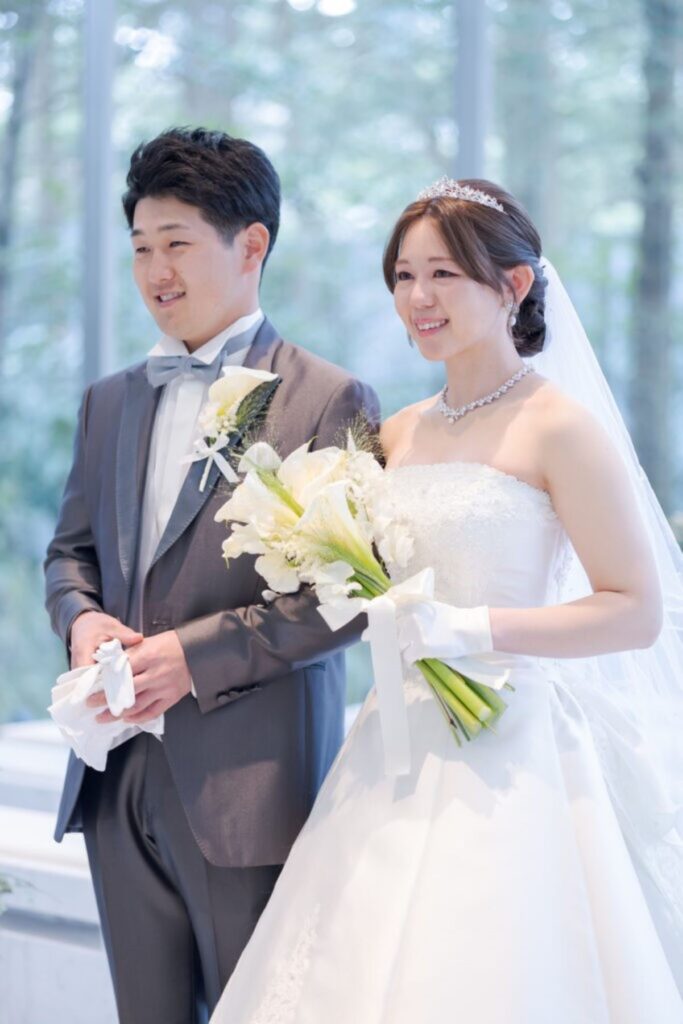 軽井沢の森に包まれたガラスのチャペル。自然光が二人を照らす、清らかでロマンチックな特別な一枚。