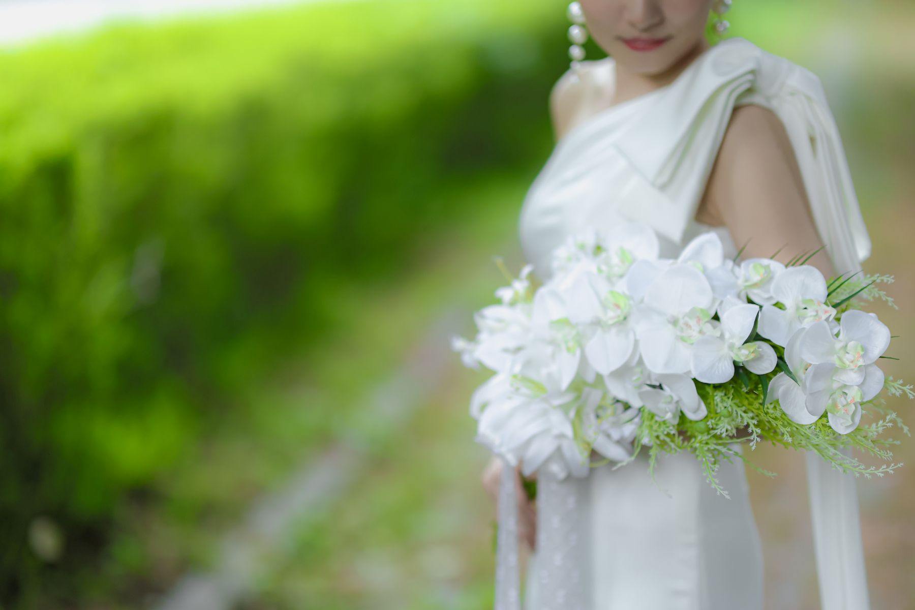 軽井沢の深い緑が引き立てる、純白のウエディングドレスとブーケ。自然光の中で叶えるロケーションフォトは、リゾートウエディングの特別な美しさ。アネーリ軽井沢で憧れの結婚式を。