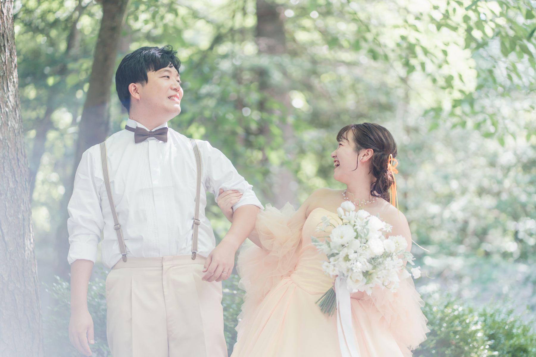 軽井沢の森の自然光の中で輝く、淡いイエローのカラードレス。おふたりの幸せな笑顔が溢れるロケーションフォトは、アネーリ軽井沢でのリゾートウエディングを彩ります。