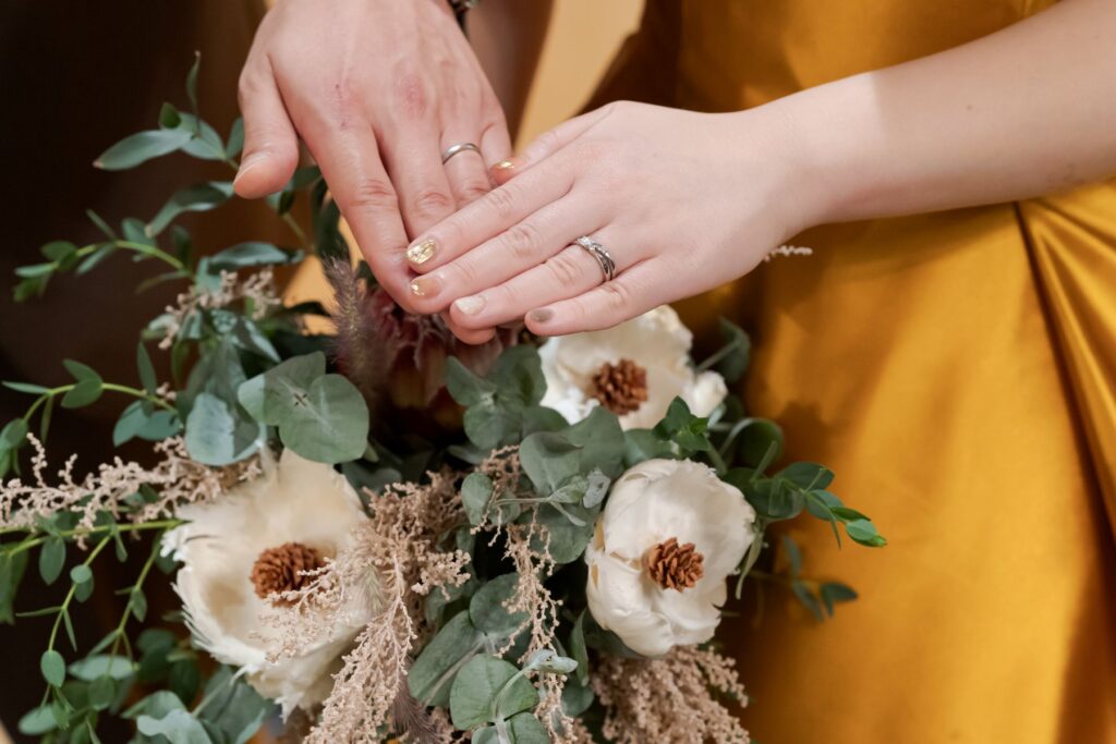 誓いの証、結婚指輪とブーケ。アースカラーのブーケとカラードレスが、軽井沢のナチュラルな雰囲気にマッチ。アネーリ軽井沢のトータルコーディネート。