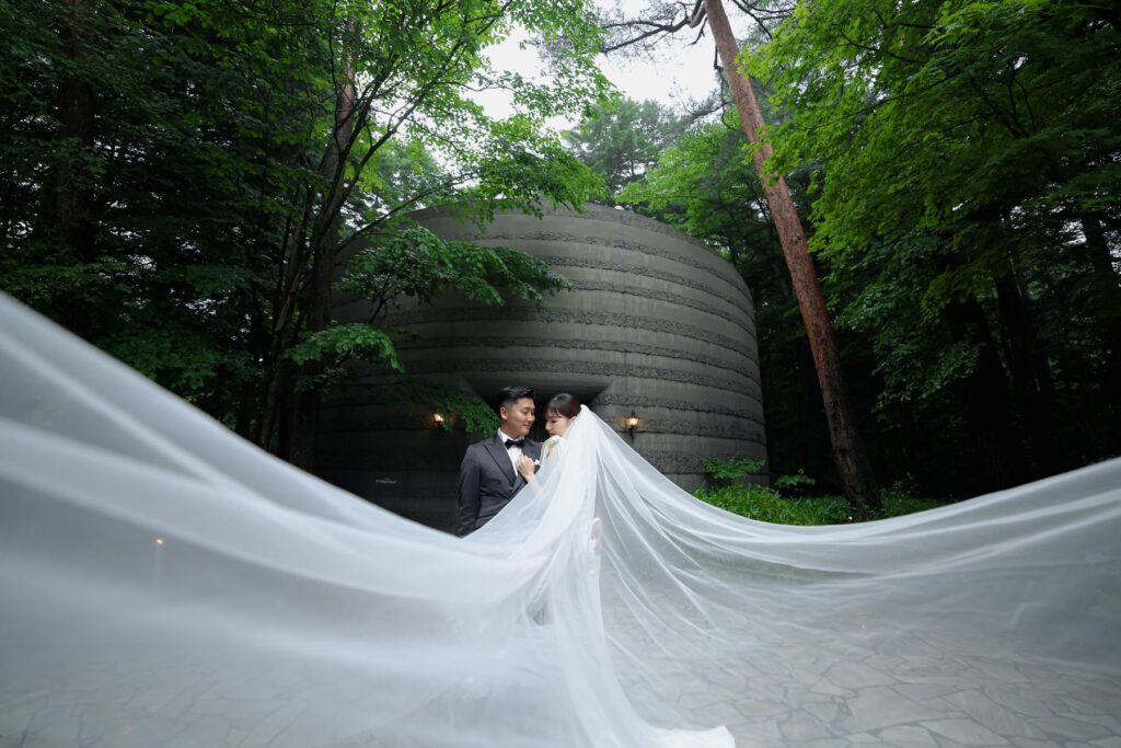 軽井沢の森でたなびくウェディングベール。ドラマティックで幻想的なロケーションフォトは、アネーリ軽井沢が誇る特別な一枚。おふたりのリゾートウエディングを形にします。