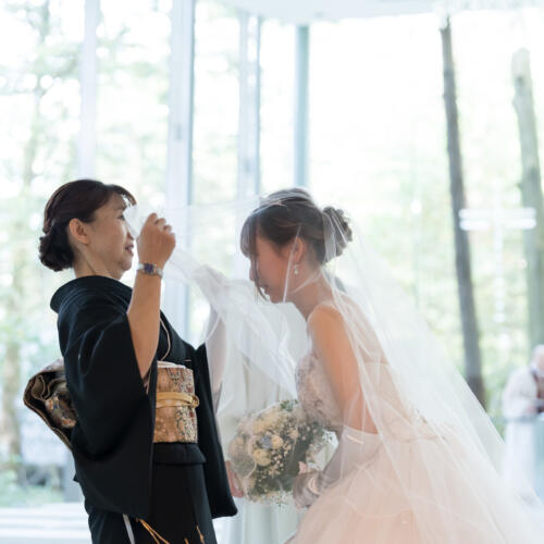 お母様から娘様へ、永遠の幸せを願う「ベールダウン」の儀式。軽井沢の美しい光の中で、家族の絆を深める感動的な結婚式を。