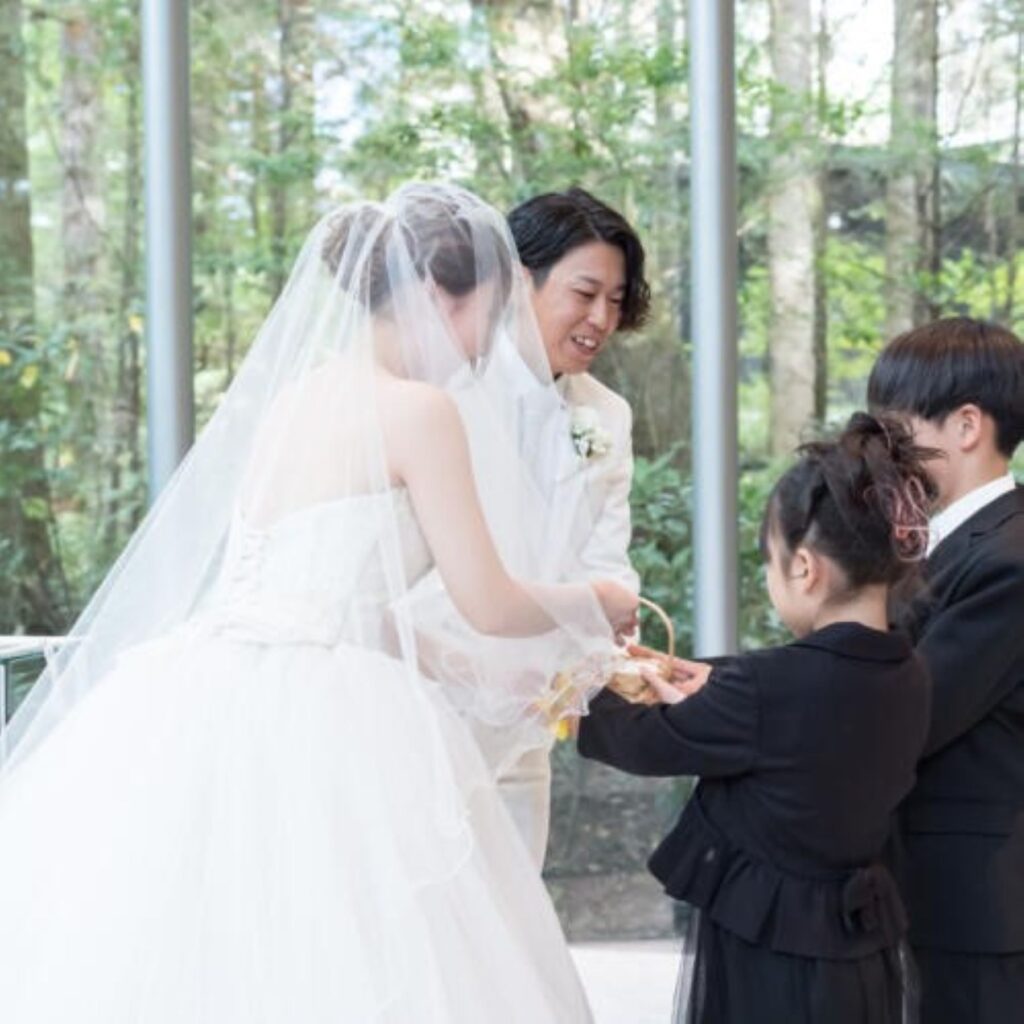森の緑が祝福するガラス張りチャペル。お子様のリングボーイ・ガール参加で、セレモニーがよりアットホームに。軽井沢の自然と共に誓う家族の絆。