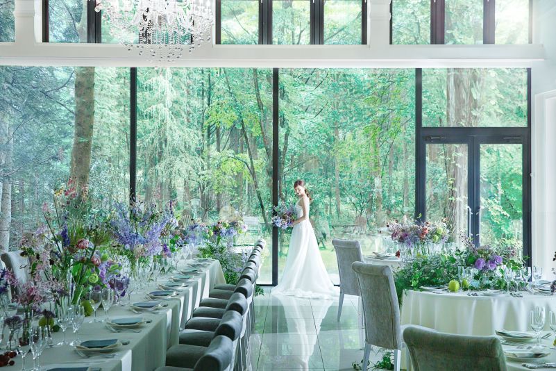 大きな窓が軽井沢の森を切り取る、白を基調とした洗練のパーティ空間。お二人のお好みに合わせたカラフルな装花が、純白の会場によく映えます。ワンランク上のおもてなしを叶えませんか。