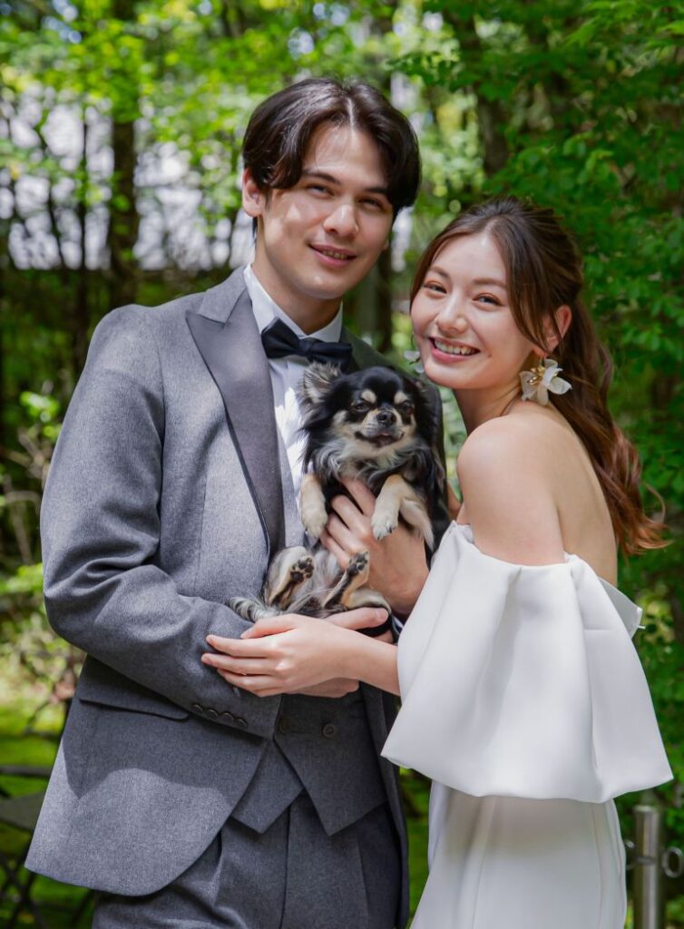 アネーリ軽井沢の結婚式。大切な家族である愛犬(チワワ)も一緒に参加できるガーデンウェディング。軽井沢の緑の中で、新郎新婦とペットが優しく微笑むウェディングフォト。