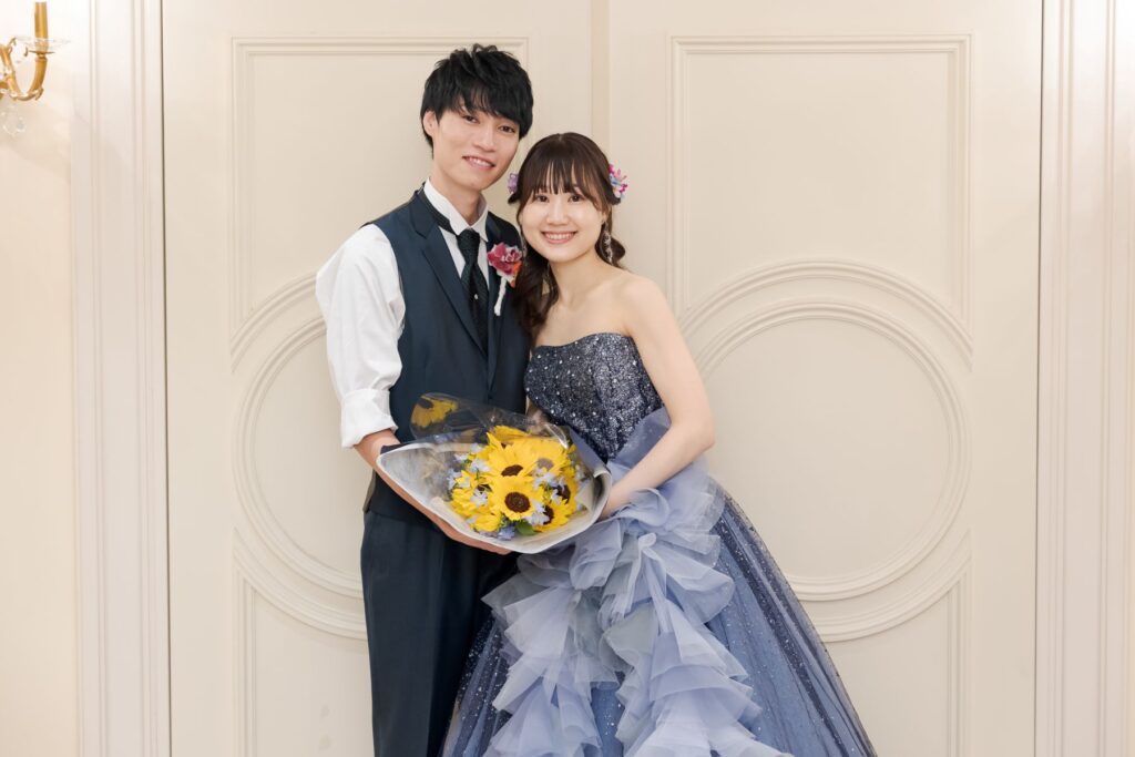 軽井沢の静かな森に映える、ネイビーのタキシードとブルードレス。シックな衣装とひまわりのブーケが織りなす、上質でおしゃれな結婚式。アネーリ軽井沢で理想のウエディングを。