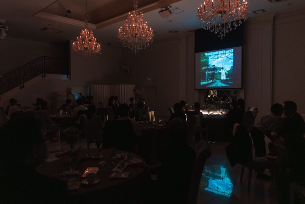 煌めくシャンデリアのもと、感動的なムービー演出。大画面での上映は、ゲストの心に深く響きます。アネーリ軽井沢で叶える、記憶に残る結婚式。