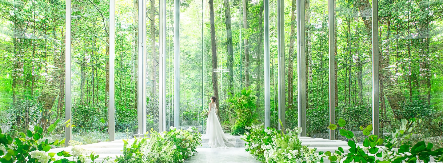 軽井沢の自然美と一体となるアネーリ軽井沢のガラスのチャペル。目の前に広がる森の木々がステンドグラスのように美しい挙式空間。リゾート婚の夢を叶える開放的なチャペルの写真。