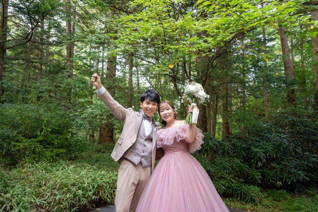 軽井沢の森で叶えるロケーションフォト!ピンクドレスが自然の緑に美しく映える、最高にハッピーな一枚です。アネーリ軽井沢でリゾート感溢れるウエディングを実現しませんか。