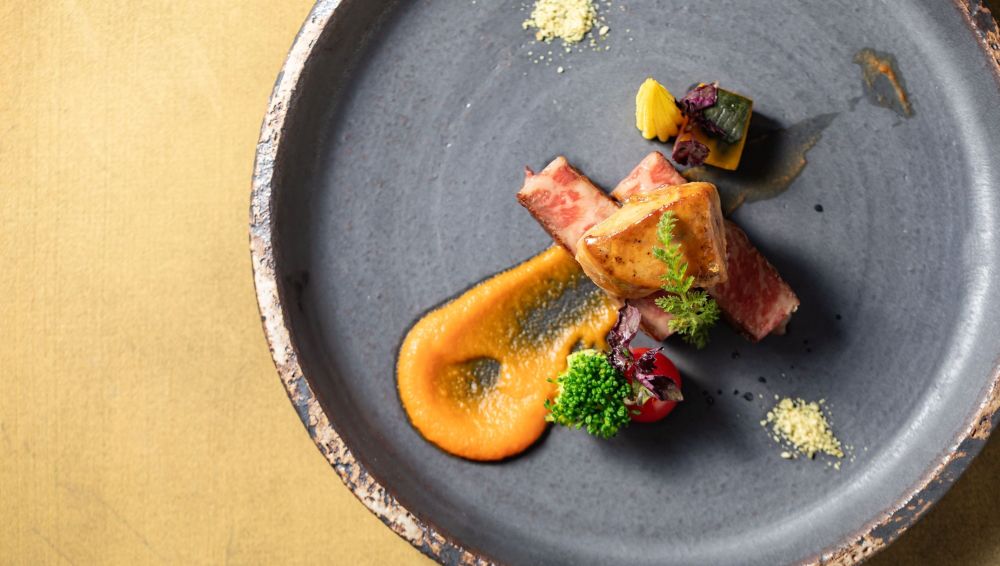 アネーリ軽井沢の結婚式フルコースで提供される、信州牛やフォアグラ、軽井沢産高原野菜を贅沢に使った芸術的なフレンチの一皿。オレンジソースの彩りが鮮やかなメインディッシュ。