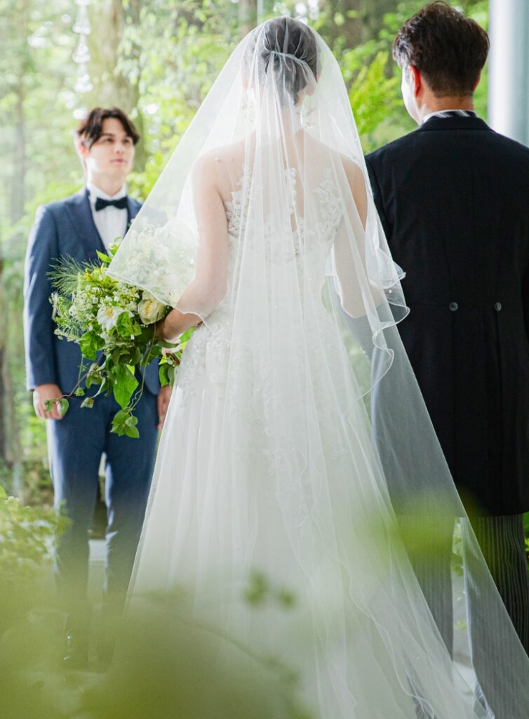 アネーリ軽井沢のチャペルで永遠の誓いへ向かう新婦と父親。新郎が待つ祭壇へ進む、親子の絆を感じさせる感動的な場面。軽井沢の森の中で叶える心温まるウェディング。