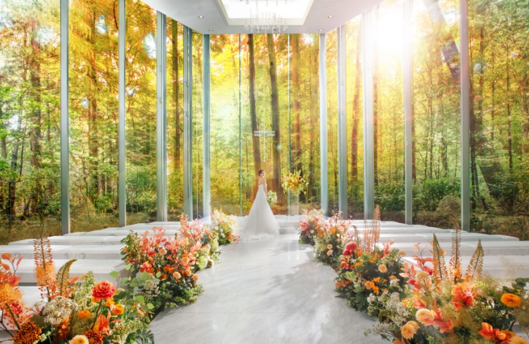 アネーリ軽井沢の紅葉ウェディング。鮮やかなオレンジに色づいた森のガラスのチャペル。光に満ちた会場と花嫁が美しい、軽井沢のリゾート婚の舞台。