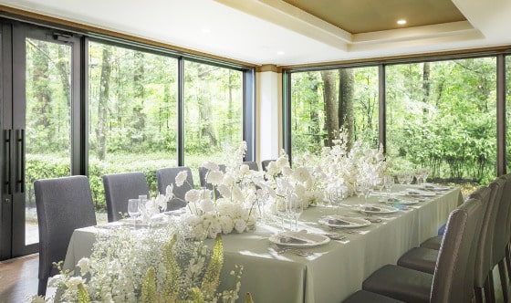 【シャングリラ】少人数結婚式に最適な会場。軽井沢の森の緑を背景に、白の装花が映えるロングテーブルでの会食会。家族や親族のみの結婚式、アットホームな会食を希望の方におすすめ。