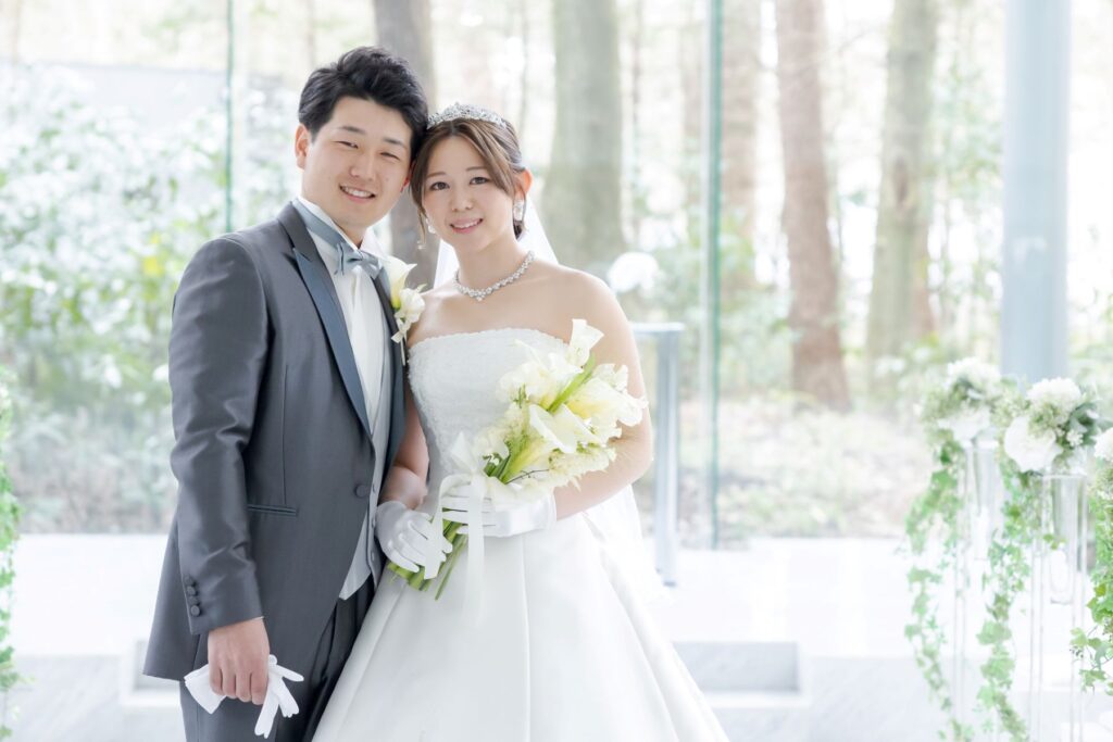 軽井沢の森に包まれた全面ガラス張りのチャペル。自然光が二人を照らす、清らかでロマンチックな特別な一枚。