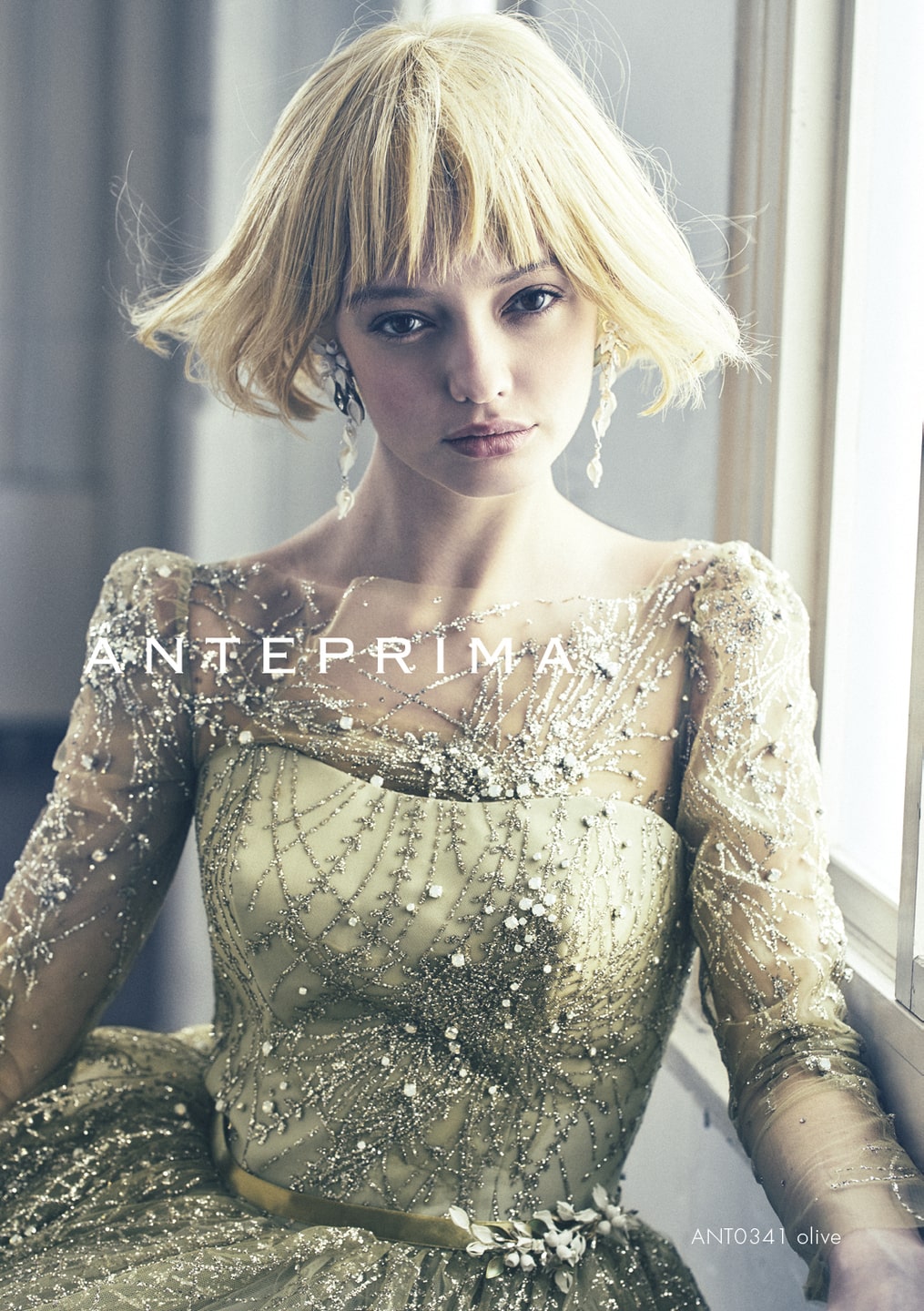 アネーリ軽井沢提携アンテプリマのオリーブ色カラードレスのアップ。シースルーの長袖とボートネックに、銀色のグリッターと刺繍が贅沢に施された、軽井沢のクラシカルな会場に合うお色直し衣装。