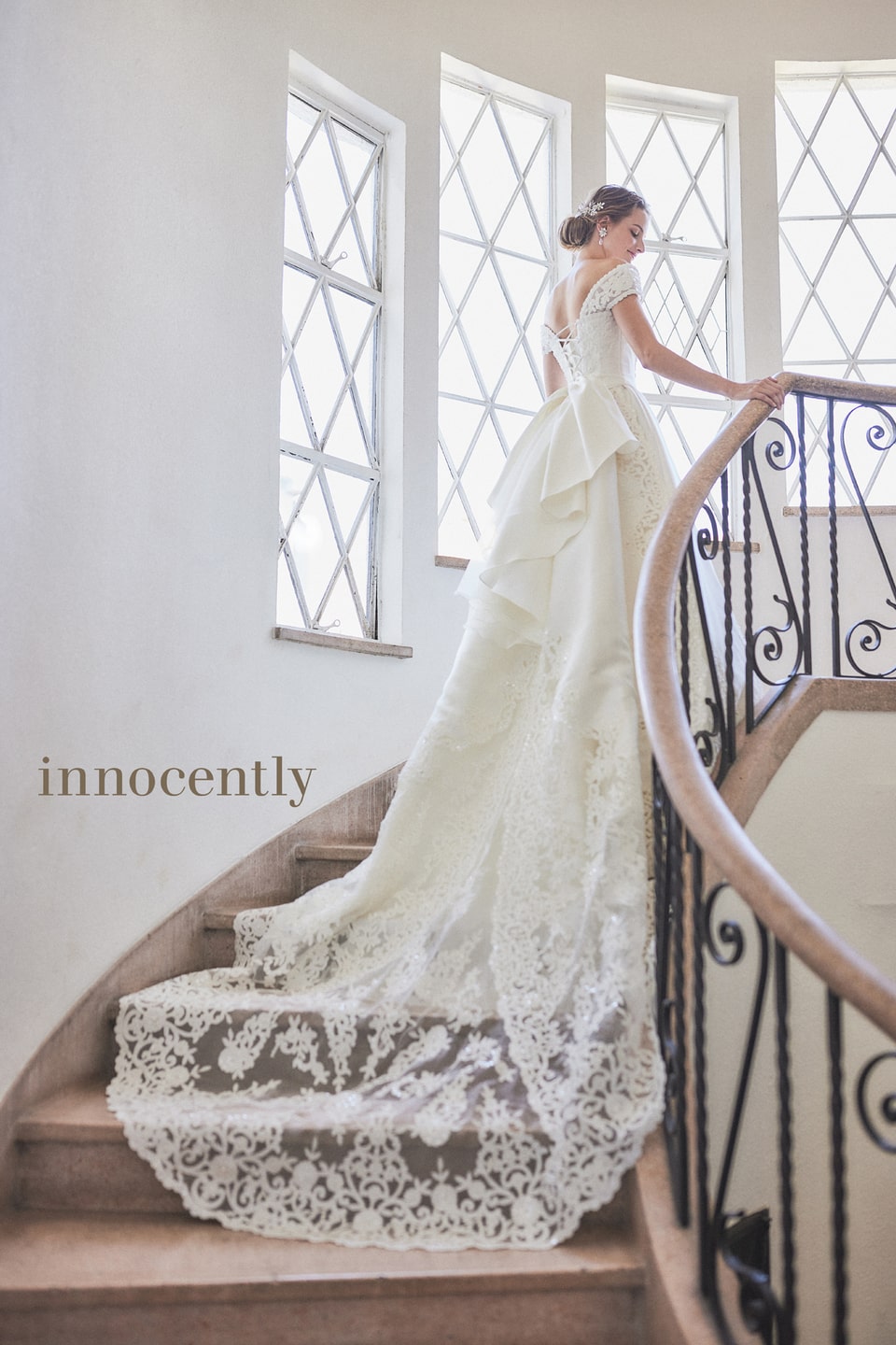 【innocently(イノセントリー)】のウェディングドレス。大きなバックリボンと、階段に広がるロングトレーン/レース刺繍が特徴的なバックスタイル。アネーリ軽井沢のチャペルや会場内の階段フォトに最適。