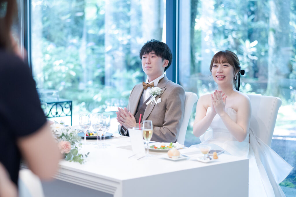 ゲストからの祝福を受け、新郎新婦の笑顔が弾けます。軽井沢の緑が背景の会場で、心温まるスピーチの時間を。理想のウエディングを叶える。