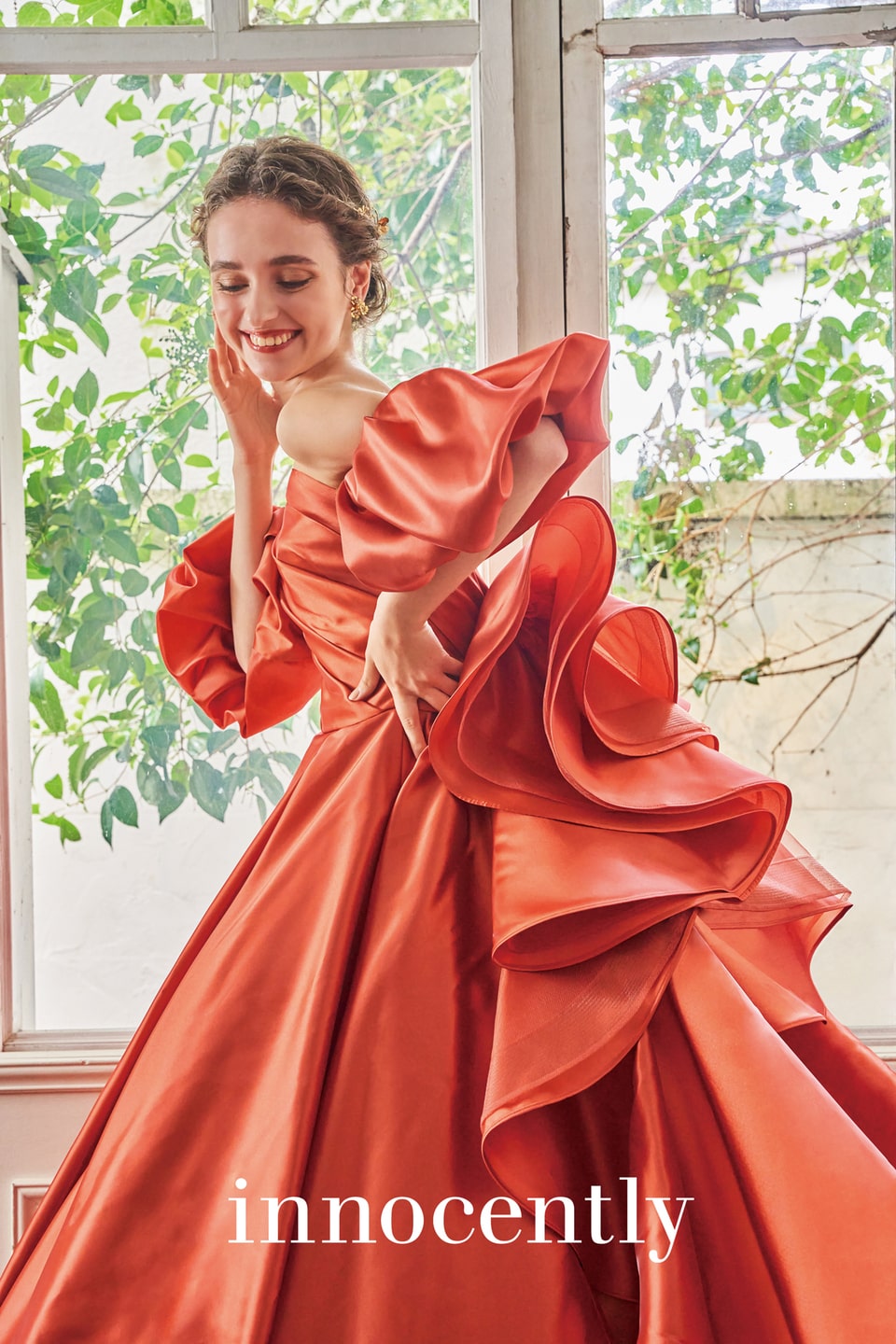 アネーリ軽井沢提携イノセントリーのテラコッタオレンジのカラードレス。ハリのあるサテンのオフショルダーと、立体的なフリルが肩とスカートに施された、軽井沢のガーデンウェディングに映える華やかなお色直しドレス。