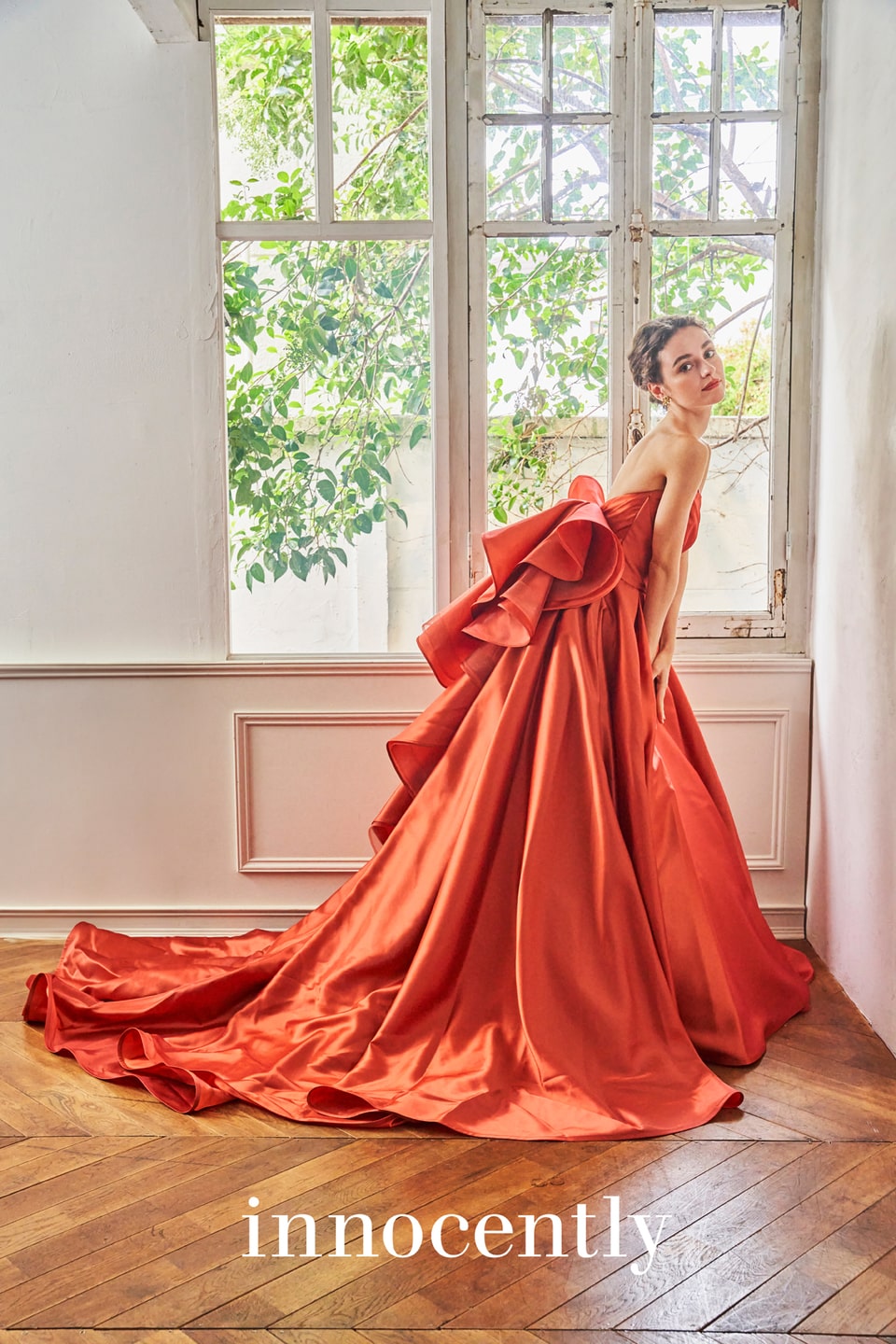 アネーリ軽井沢提携イノセントリーのテラコッタオレンジのカラードレス。ハリのあるサテン生地と背中の大きなフリルリボンが特徴的。クラシカルな軽井沢の洋館やガーデンに映える、ドラマティックなお色直しの一着。