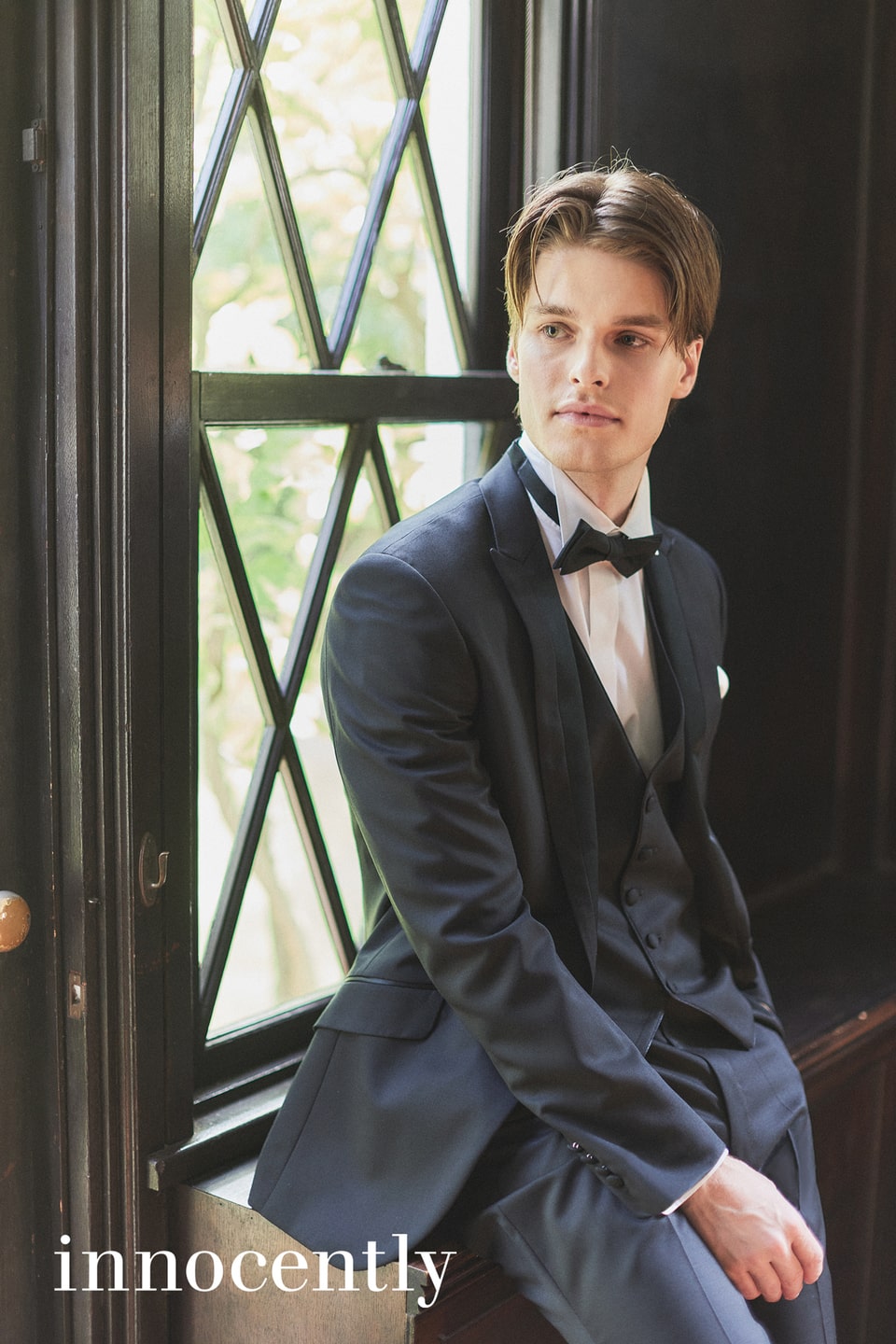アネーリ軽井沢提携innocently (イノセントリー) のネイビーのタキシード (新郎衣装)。ピークドラペルのジャケットとボウタイで、フォーマルかつモダンな印象。軽井沢のチャペルやガーデンウェディングでの新郎の装いに最適。花嫁のカラードレスにも合わせやすい人気のベーシックな1着。