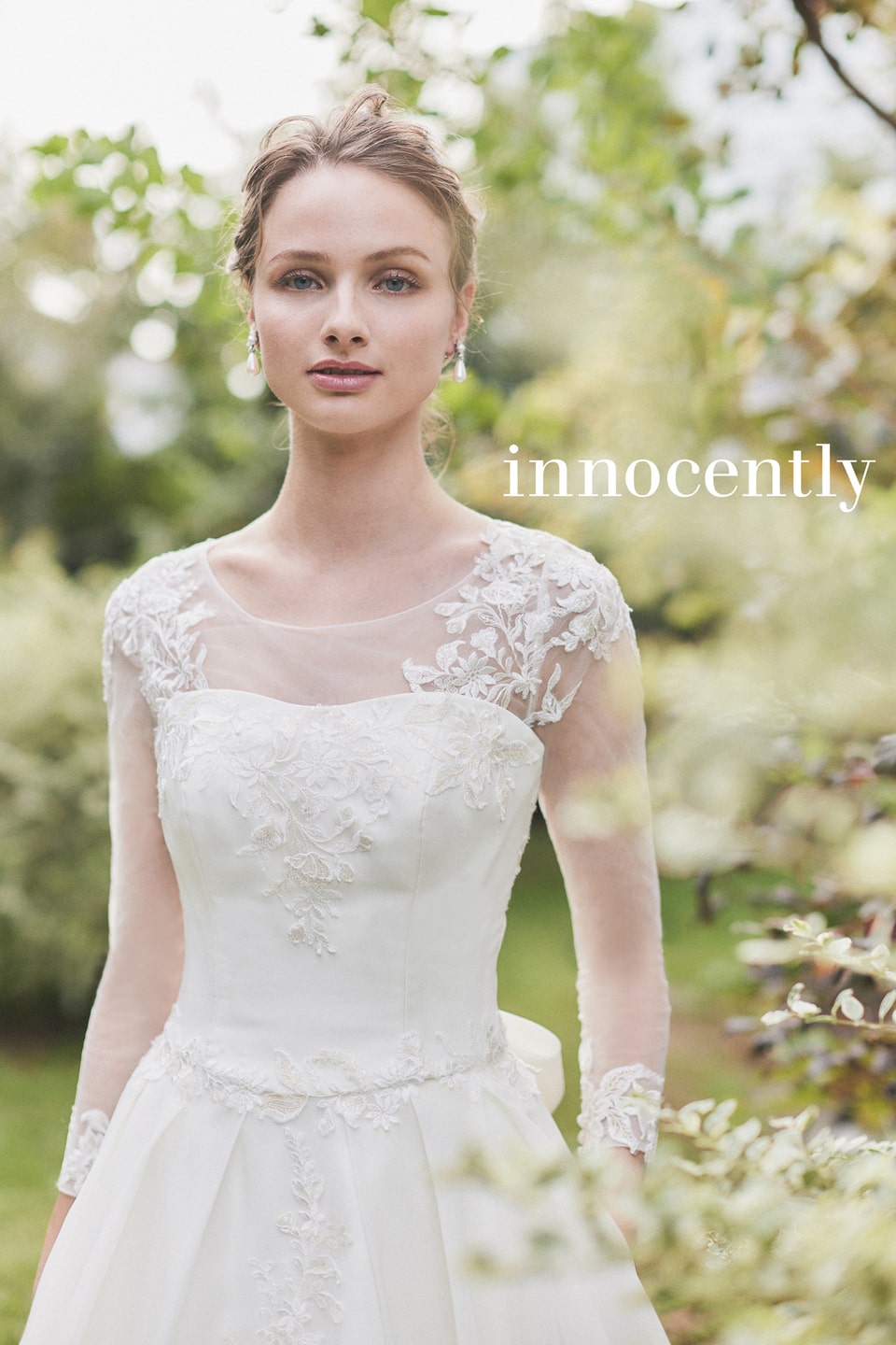 【innocently(イノセントリー)】のウェディングドレス。オーガンジー素材の長袖とデコルテのレース刺繍が清楚なAライン。アネーリ軽井沢のガーデンウェディングにぴったりのナチュラルな花嫁姿。