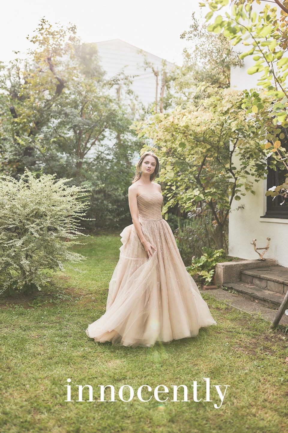 アネーリ軽井沢提携イノセントリーのベージュ系カラードレス。テラコッタやゴールドにも見える繊細なグリッターチュールが、軽井沢のガーデンの緑に溶け込むナチュラルで上品なお色直しスタイル。