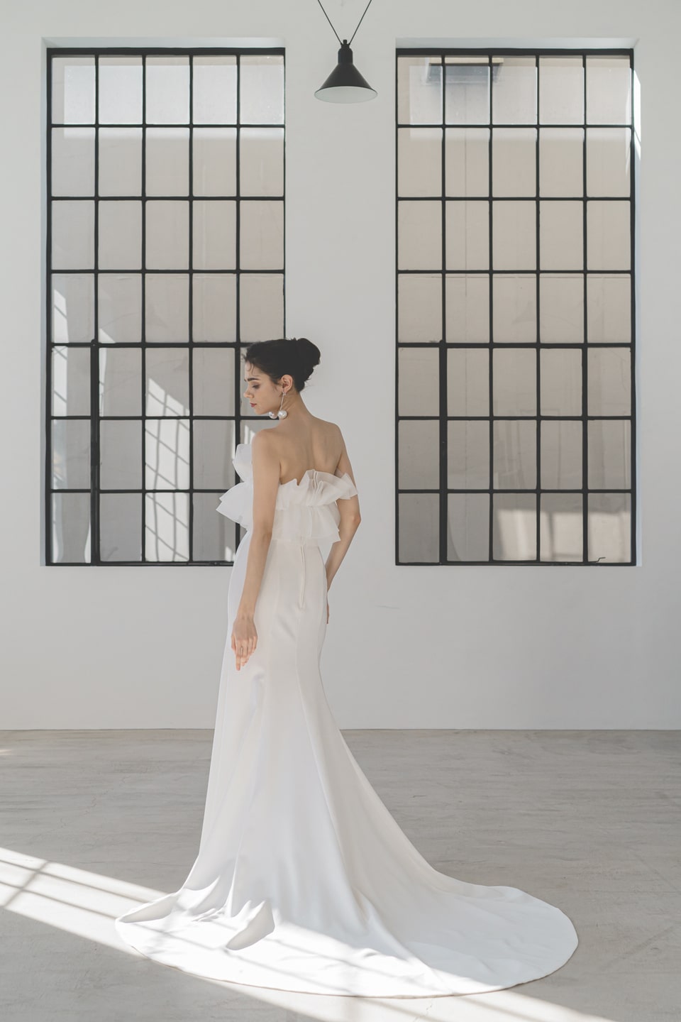 【アネーリ軽井沢】のモダンな空間に映えるスレンダーラインのウェディングドレス。シンプルなサテン生地と、背中のフリルやビッグリボンがアクセントのバックスタイル。インポート風の大人花嫁に。