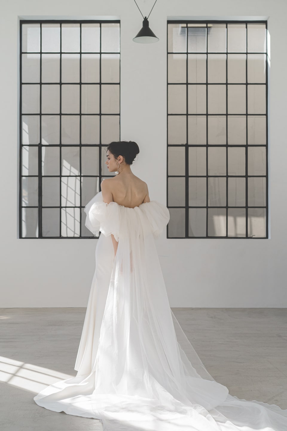 【アネーリ軽井沢】のモダンな空間に映えるウェディングドレス。大きなオフショルダーのボリュームスリーブと、流れるようなスレンダーラインがシンプルで洗練された印象。軽井沢のリゾートウェディングに最適なインポート風ドレスです。