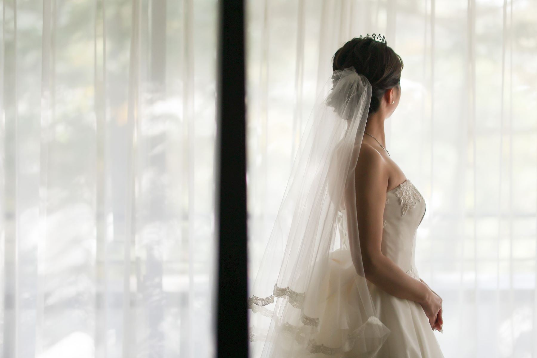 挙式前の静かなひととき。軽井沢のやわらかな自然光が、花嫁の純白のドレスとベールを美しく照らします。最高の瞬間に備える特別なブライズルームをご用意しています。