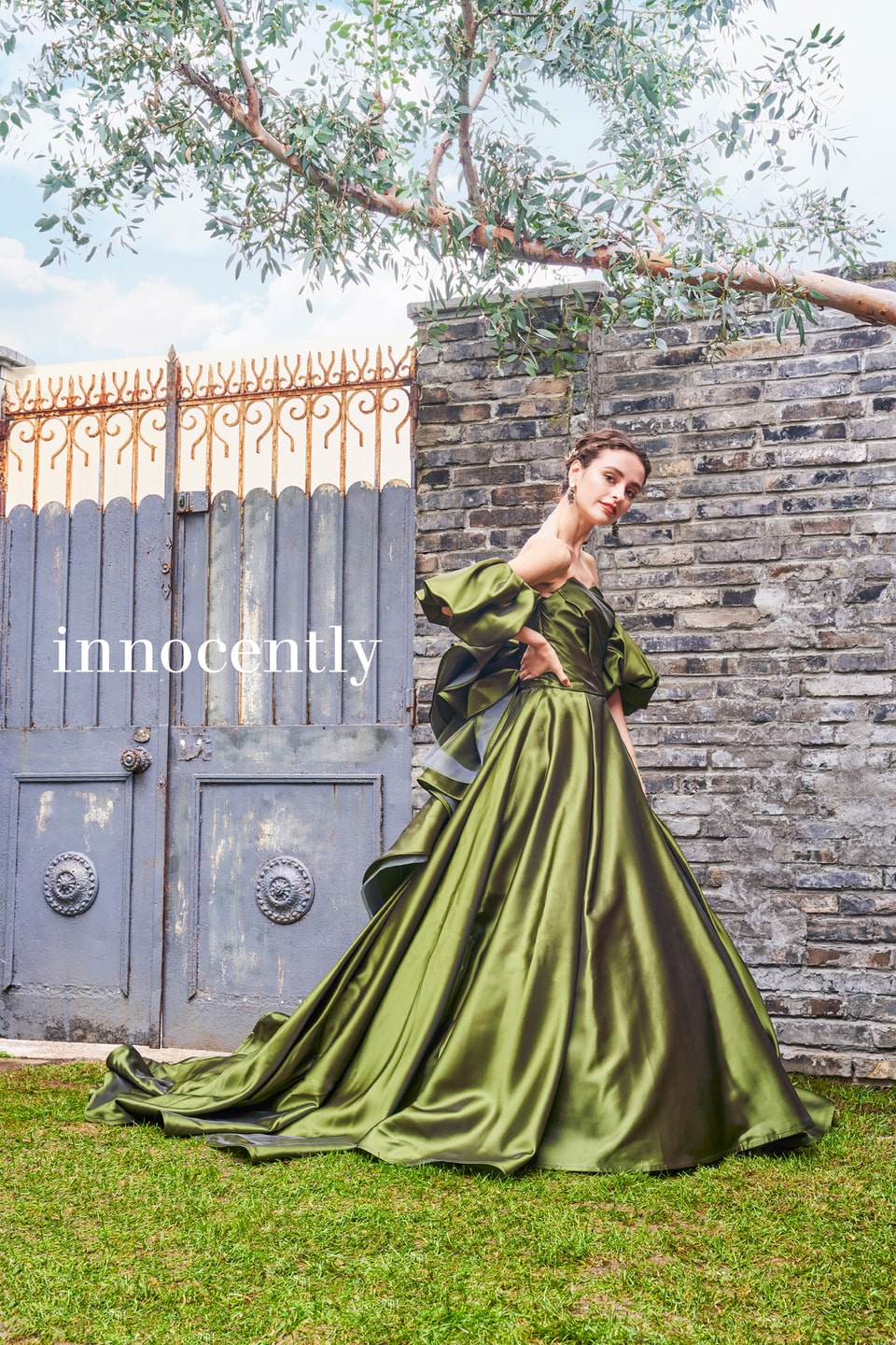 アネーリ軽井沢提携イノセントリーのオリーブグリーンのカラードレス。ハリのあるサテン生地とボリューミーなオフショルダーが特徴的で、軽井沢のガーデンウェディングに映える大人のお色直しスタイル。