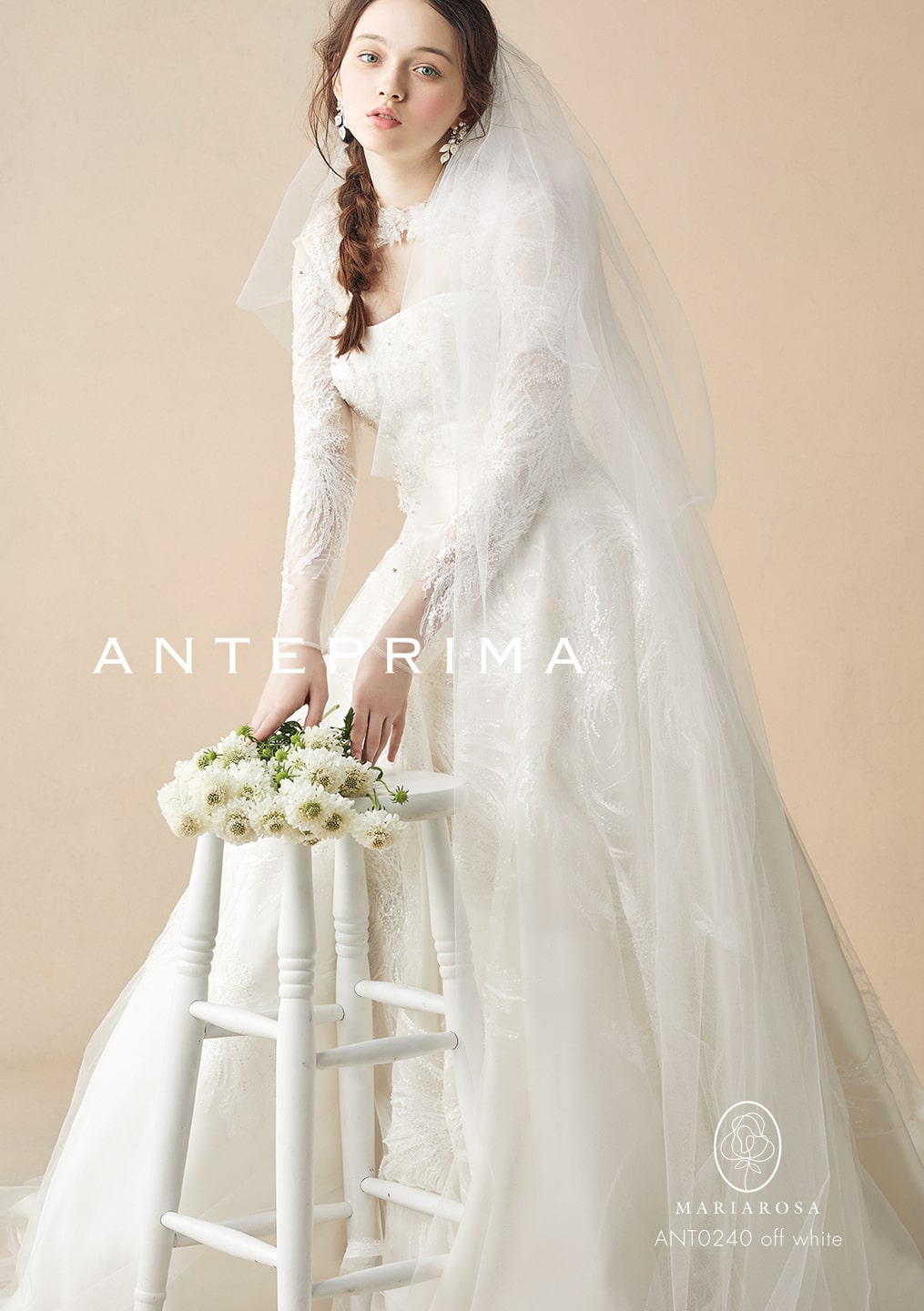 アンテプリマの長袖レースドレス。オフホワイトのチュール素材に、胸元から袖、スカートまで施された繊細な刺繍レースが特徴。ベールとブーケを持った花嫁の清楚でクラシカルな姿。