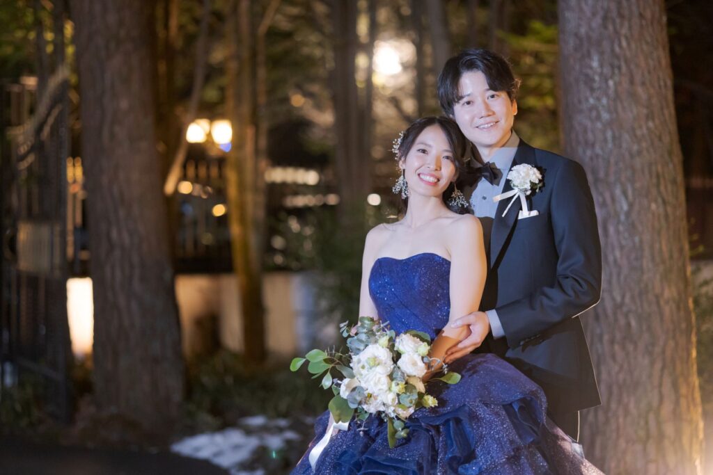 軽井沢の森で叶える、ナイトウェディング。幻想的な光がふたりを照らす、ロマンティックな一枚です。カラードレスが映える特別なフォトジェニックな時間を。