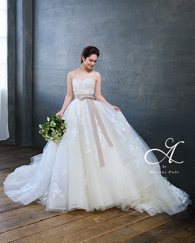 A by Hatsuko Endo(ハツコエンドウ)のチュールウェディングドレス。繊細なレースとグレイッシュなサッシュリボンがナチュラルでモダンな印象。アネーリ軽井沢のガーデンや木の床に映える、Aラインの大人フェミニンドレス。