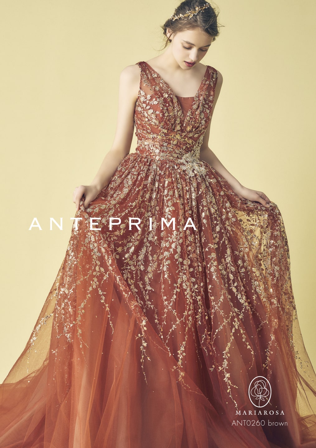 アネーリ軽井沢提携。ANTERPRIMA (アンテプリマ) × MARIAROSA のブラウンのカラードレス (品番: ANT0260)。深いブラウンにゴールドのフラワー刺繍とグリッターがゴージャスに輝くAライン。軽井沢の森のロケーションフォトや、大人っぽいお色直しにぴったりの洗練されたデザイン。