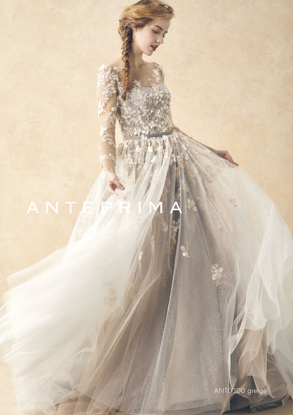 アネーリ軽井沢提携ドレス。ANTERPRIMA (アンテプリマ) の大人っぽいグレージュのカラードレス (品番: ANT0300)。長袖(ロングスリーブ)と胸元からスカートに流れるゴールドのフラワーモチーフ刺繍が上品で、軽井沢のクラシカルなチャペルや秋・冬の結婚式に最適。お洒落な花嫁に人気の1着。
