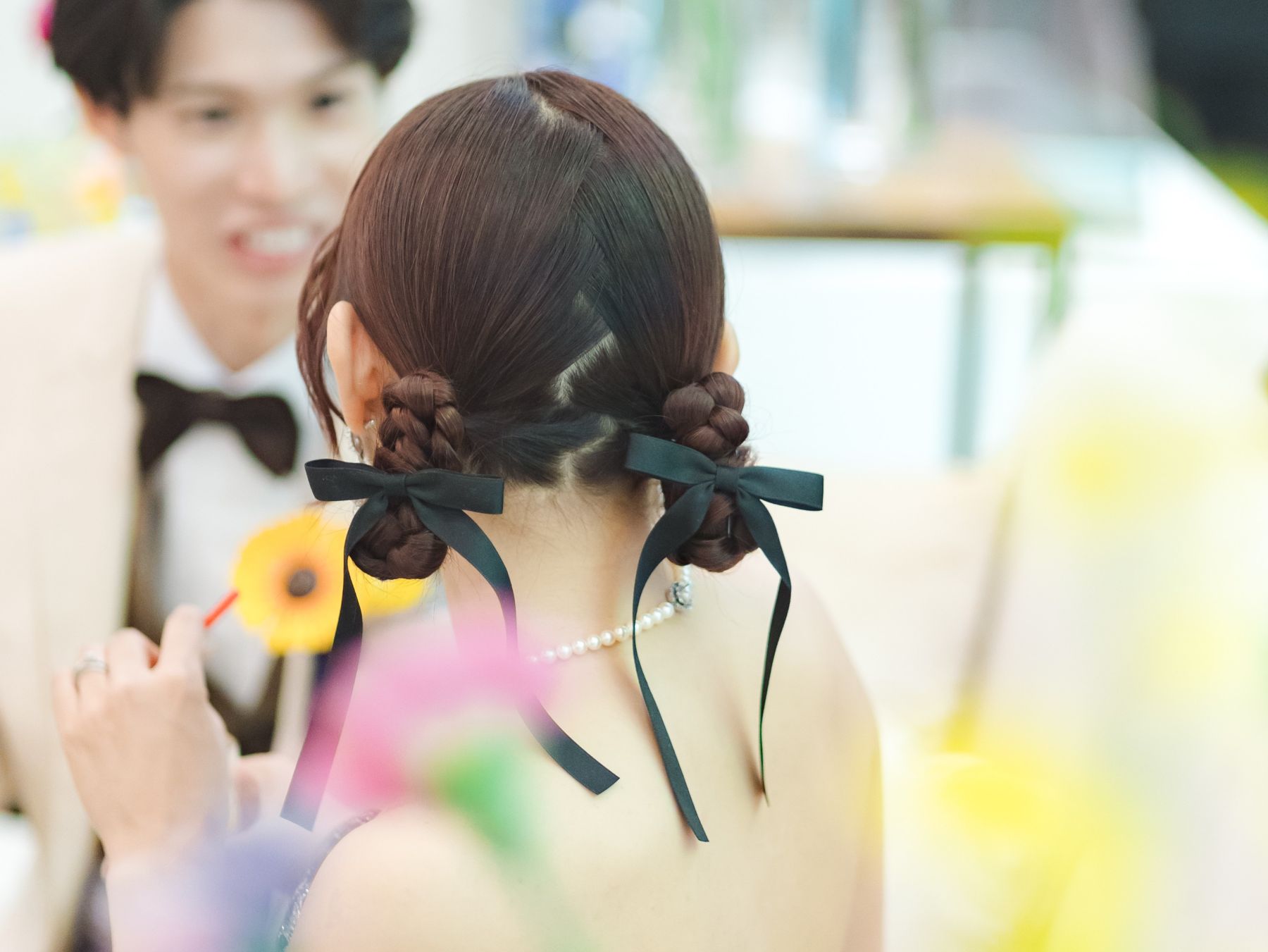 お色直し後のヘアスタイルにもこだわりを。トレンドの「玉ねぎヘア」に黒のリボンとパールのネックレスで、遊び心と上品さをプラス。個性際立つおしゃれな花嫁に。