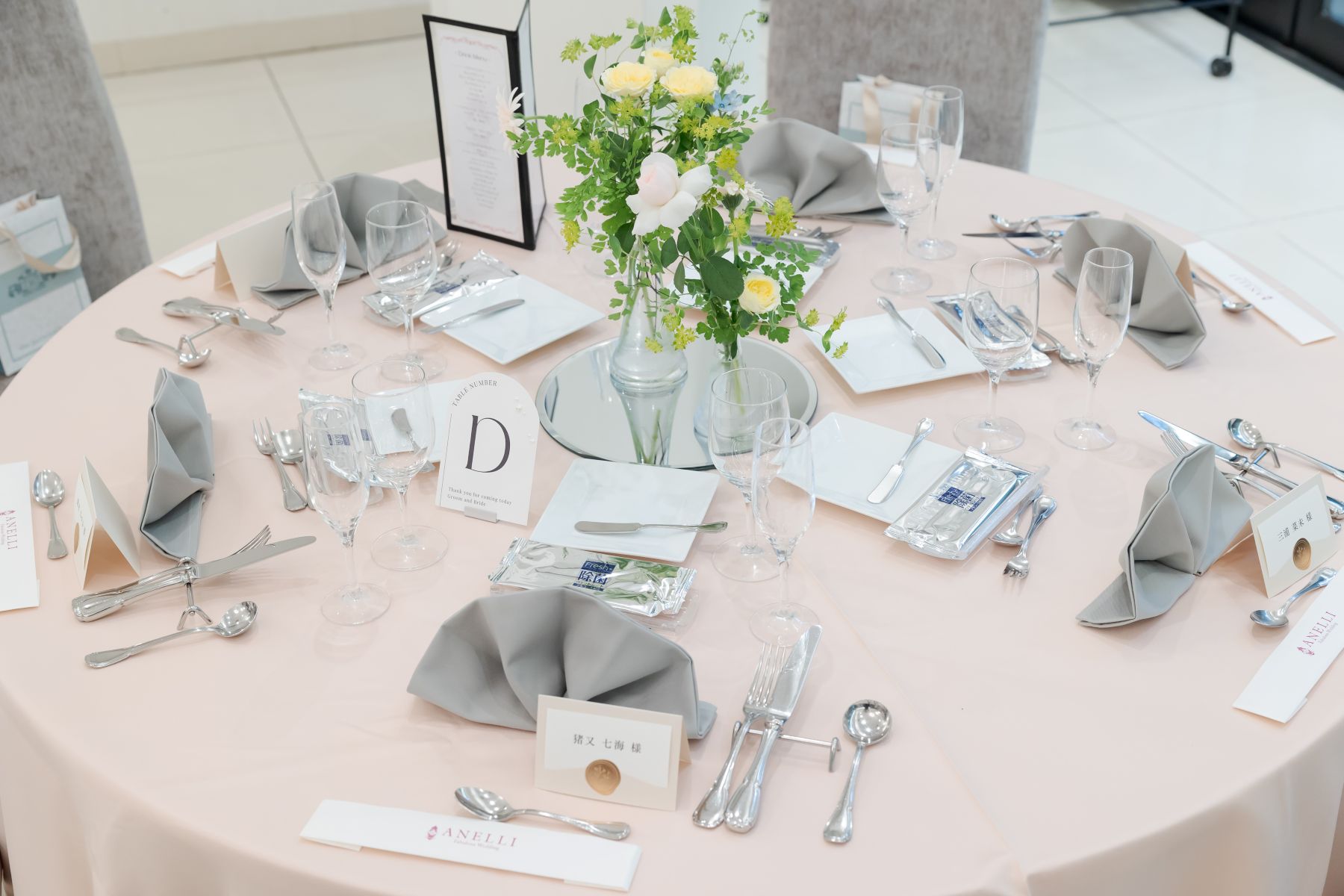 「軽井沢の自然光が映える、上品なテーブルコーディネート。淡いピンクと洗練されたグレー、鏡上の装花で、軽井沢ウェディングの上質なひとときを演出します。」