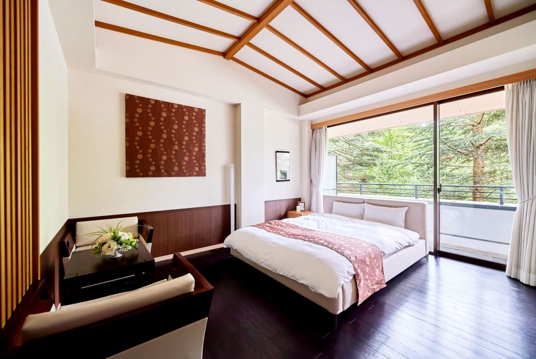 【アネーリ軽井沢の宿泊】軽井沢ウェディングで利用可能なスイートルーム。和の要素も取り入れたモダンで落ち着いた内装で、大きな窓からは豊かな軽井沢の緑を眺望。結婚式前後もリラックスして過ごせる新郎新婦やゲスト向けの客室。軽井沢リゾートウェディングに最適な施設。