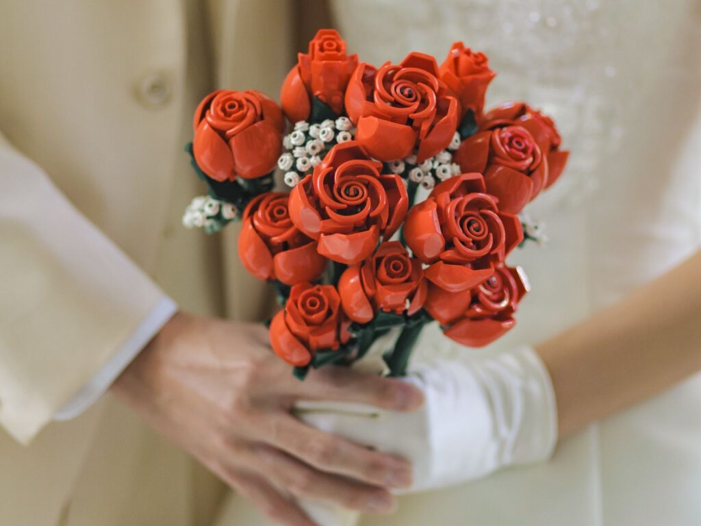 鮮やかな赤いローズのブーケが、花嫁の想いと幸せを象徴する一枚。純白のドレスとのコントラストが美しく、挙式シーンをより印象的に演出します。細部までこだわった装花が、特別な一日を彩ります。