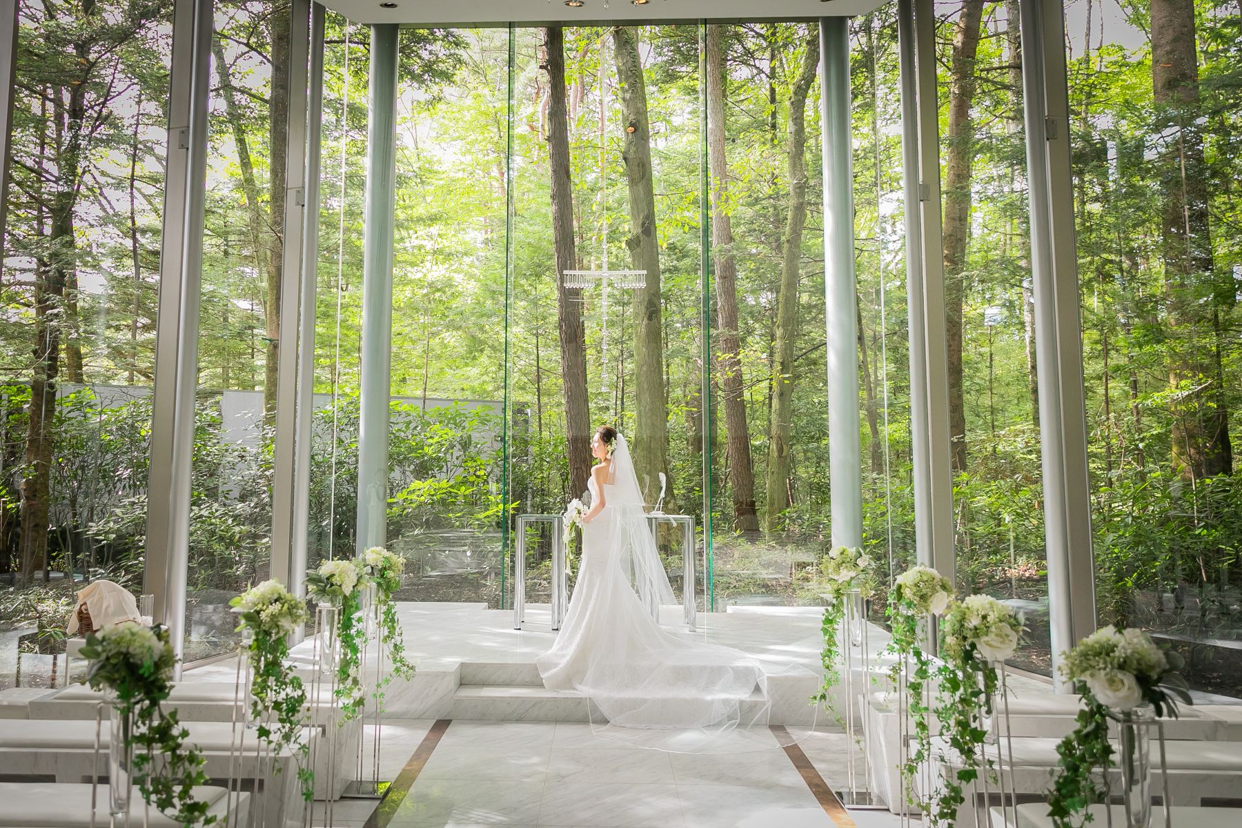 軽井沢の豊かな森に溶け込むガラス張りのチャペル。自然光が降り注ぐ空間で、四季を感じながら叶える上質なウェディング。アネーリ軽井沢ならではの静寂と透明感が、永遠の誓いを美しく彩ります。