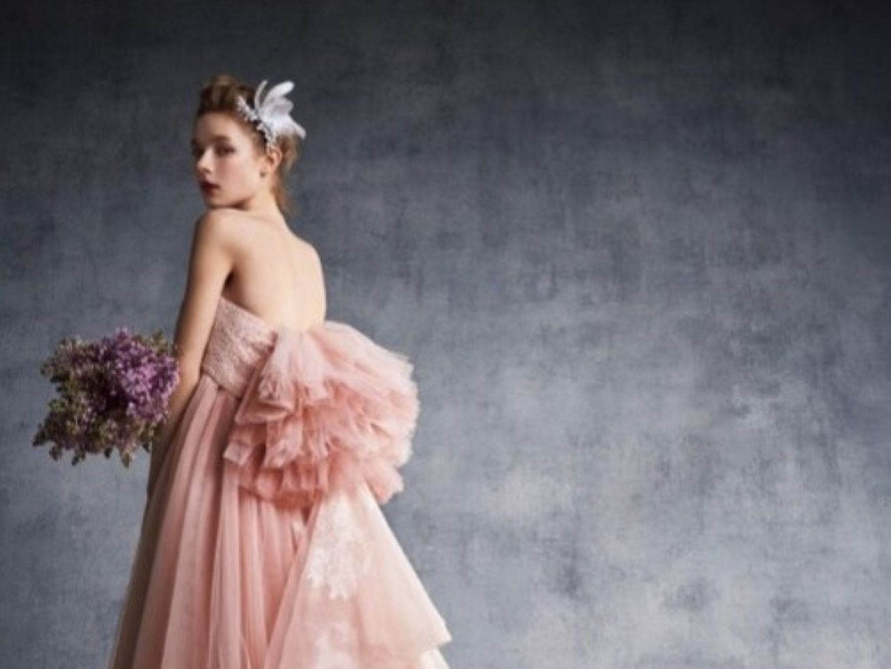 やわらかなピンクカラーが印象的なドレススタイル。繊細なチュールと立体感のあるバックデザインが花嫁の魅力を引き立て、前撮りやフォトウエディングにもおすすめの一着です。