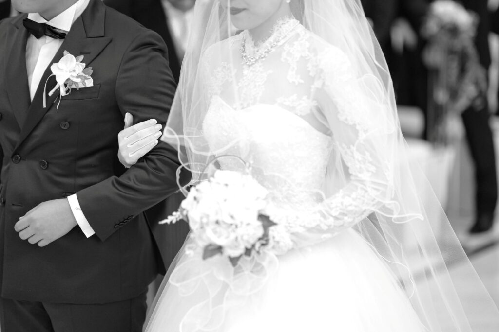 クラシカルなモノクロ写真が、挙式の緊張感と誓いの瞬間をより美しく演出。大切な人の腕に手を添え、一歩ずつ進むその姿は、軽井沢で叶える結婚式の特別な始まりを印象的に残します。
