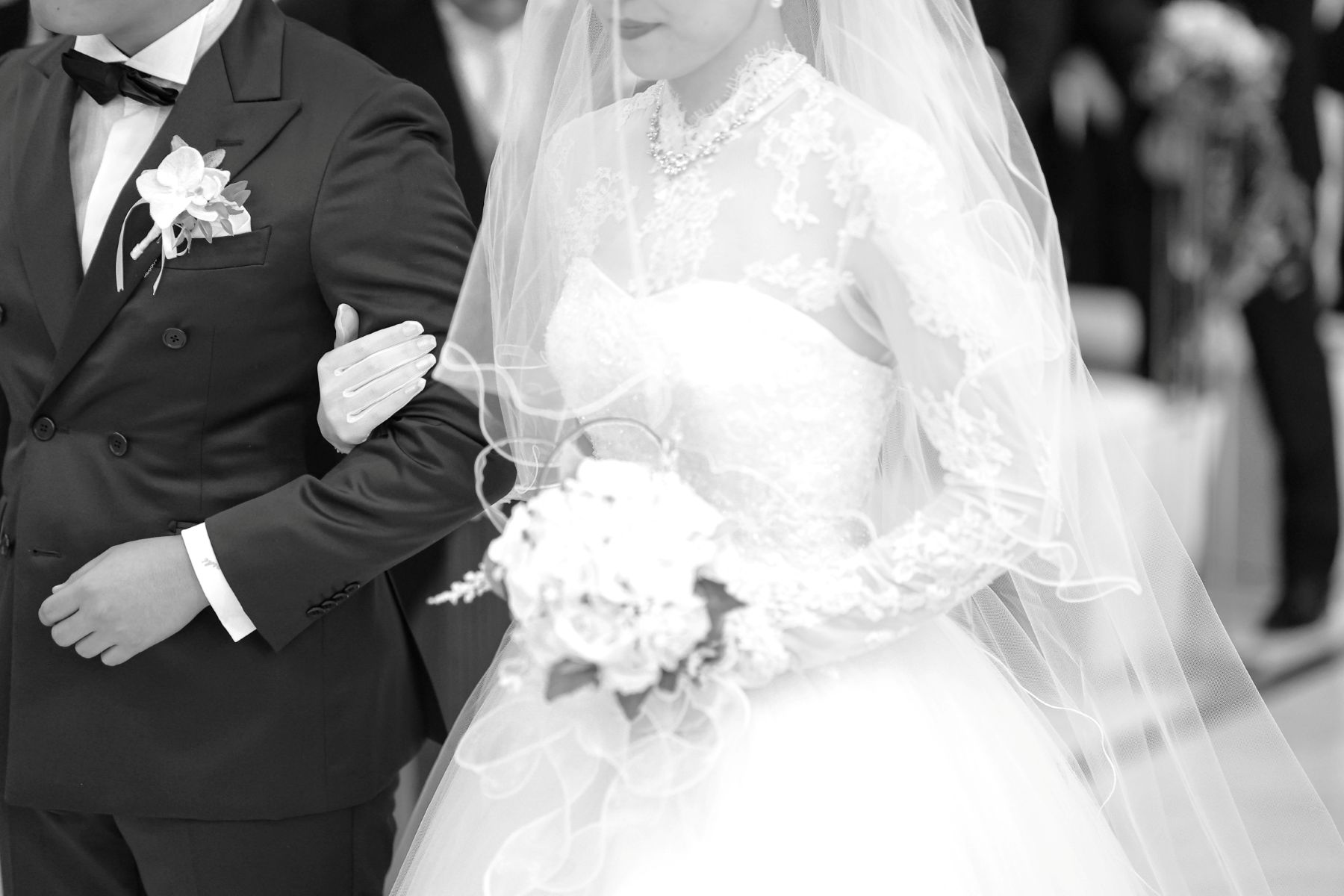 クラシカルなモノクロ写真が、挙式の緊張感と誓いの瞬間をより美しく演出。大切な人の腕に手を添え、一歩ずつ進むその姿は、軽井沢で叶える結婚式の特別な始まりを印象的に残します。