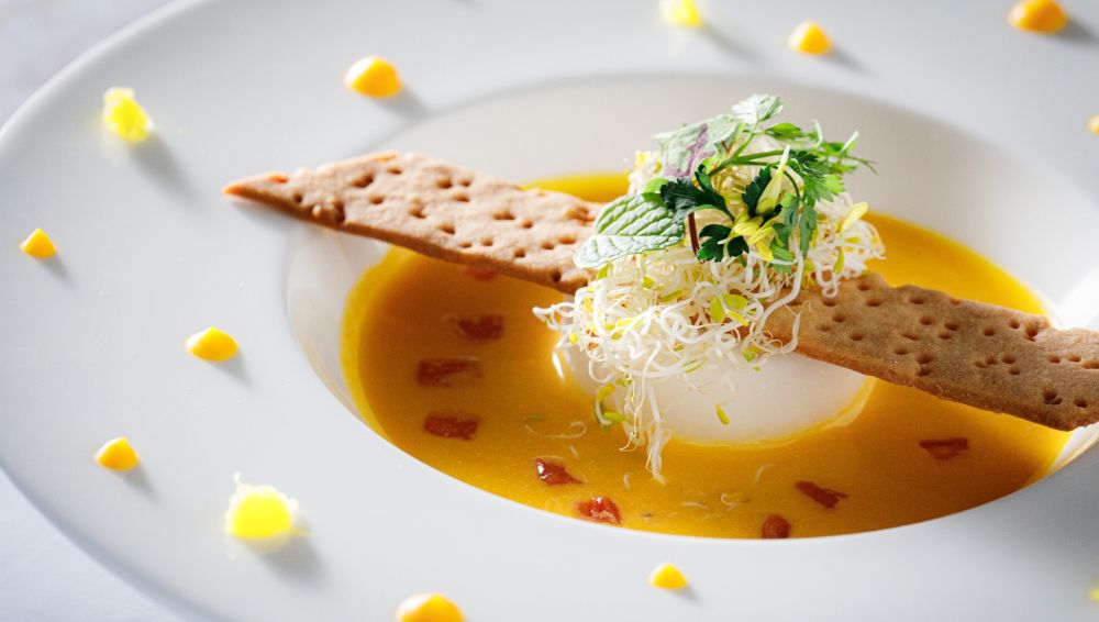 アネーリ軽井沢の婚礼料理：季節野菜のポタージュ。サクサクのチュイルとフレッシュハーブを添えた、モダンで鮮やかな一皿。