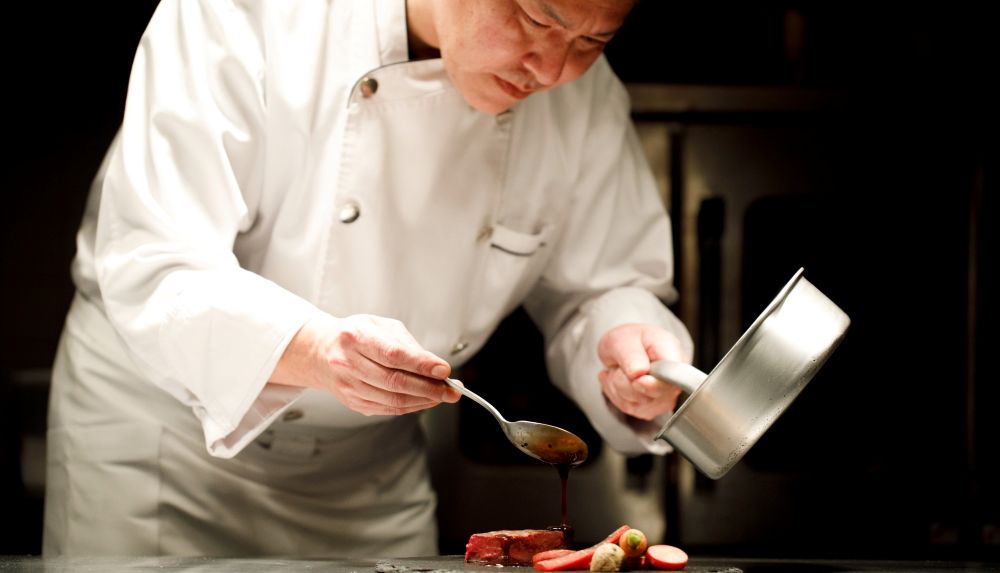 アネーリ軽井沢の専属シェフが、婚礼料理の仕上げにソースをかける様子。軽井沢の食材を活かしたこだわりのフレンチ。