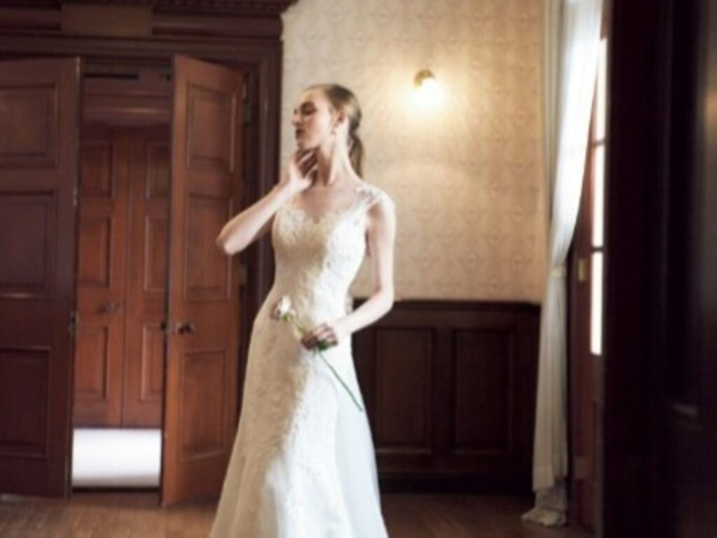 軽井沢の自然光が差し込むクラシカルな空間で、美しく映えるスレンダーラインのウェディングドレス。上品なレースと繊細なシルエットが花嫁の魅力を引き立てる、アネーリ軽井沢ならではの洗練された一着です。